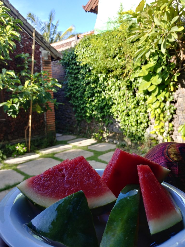having a water melone in front of the bungalow in Amed